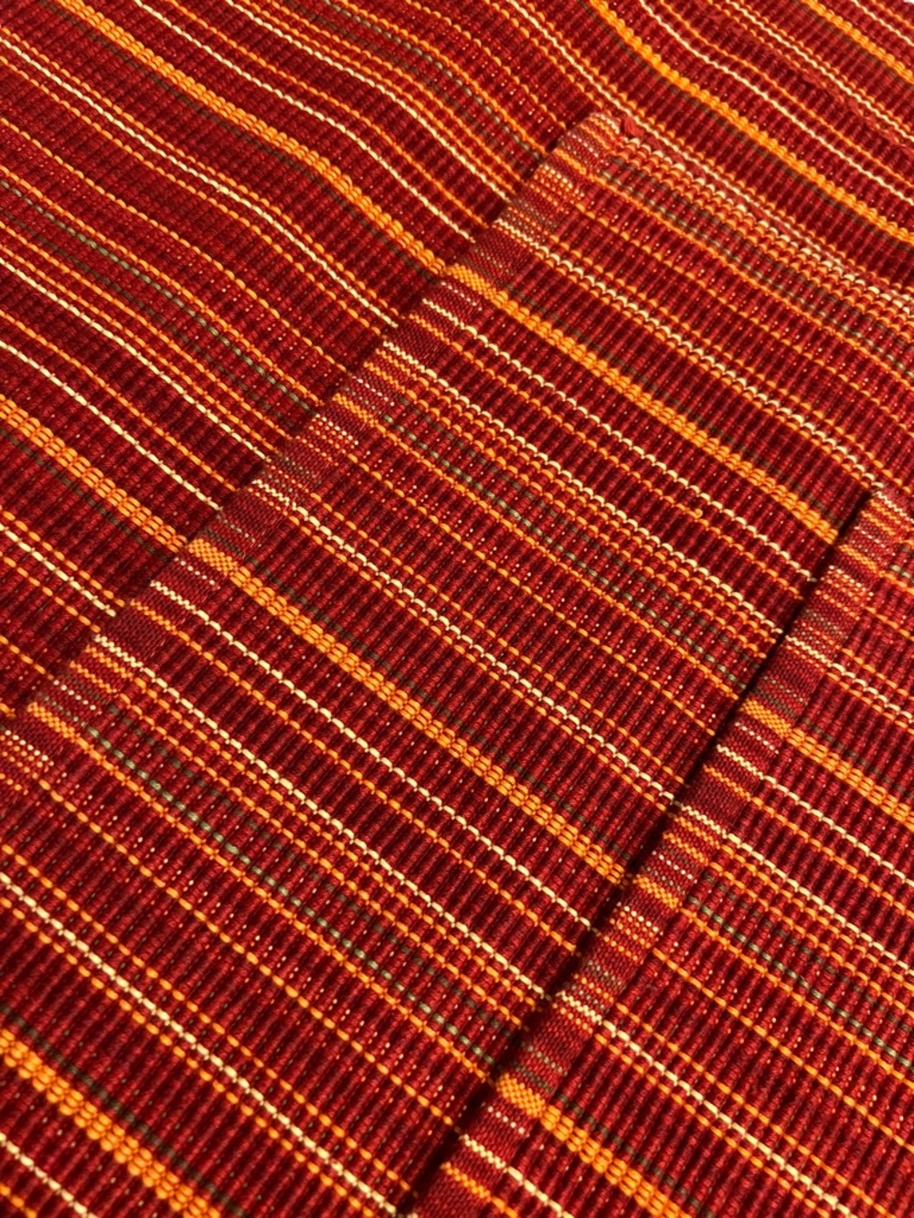 Set of 4 red, maroon, orange and cream colored woven cotton blend placemats